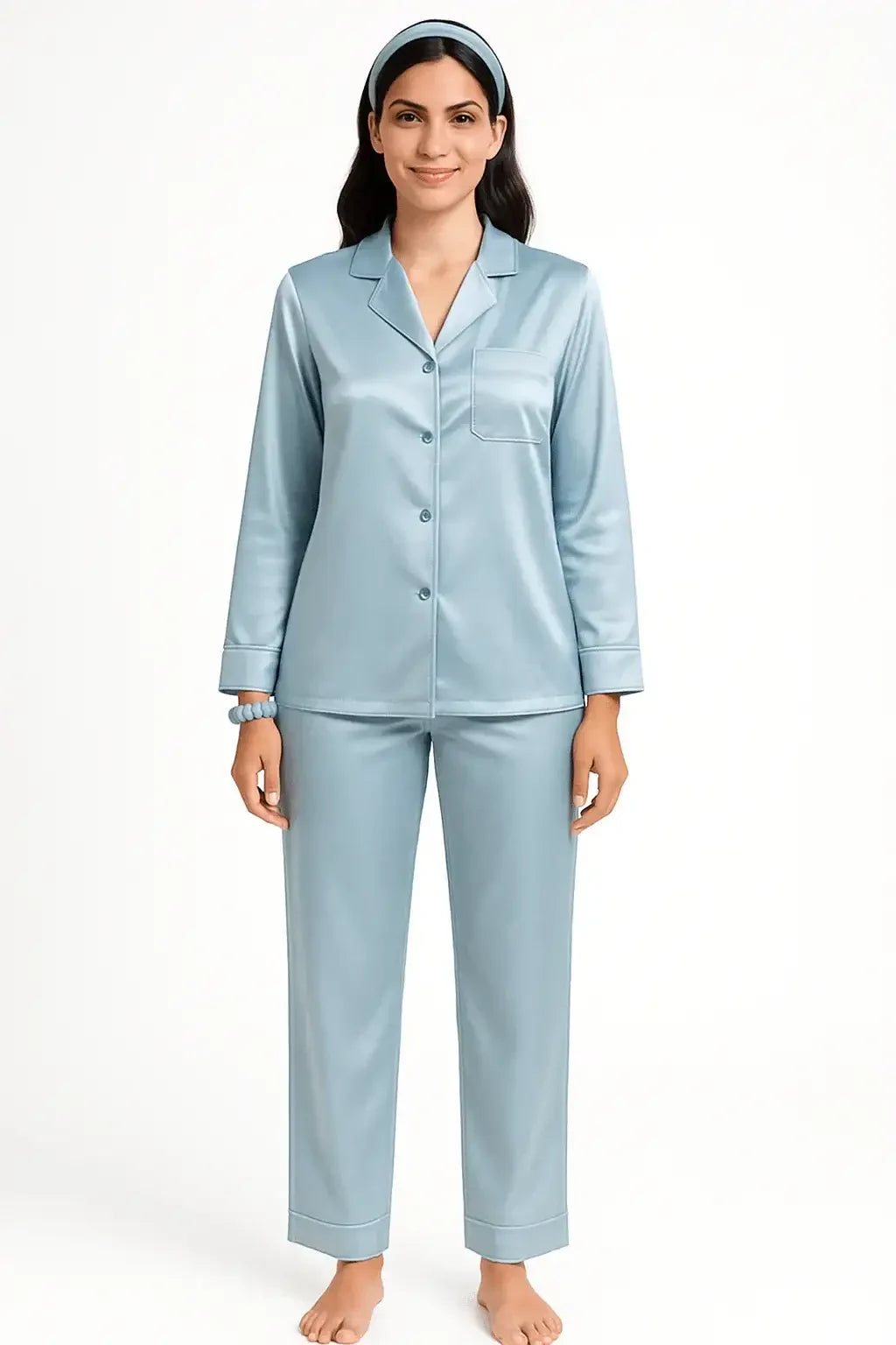 Woman wearing light blue satin button-up pajama set with matching headband and scrunchie