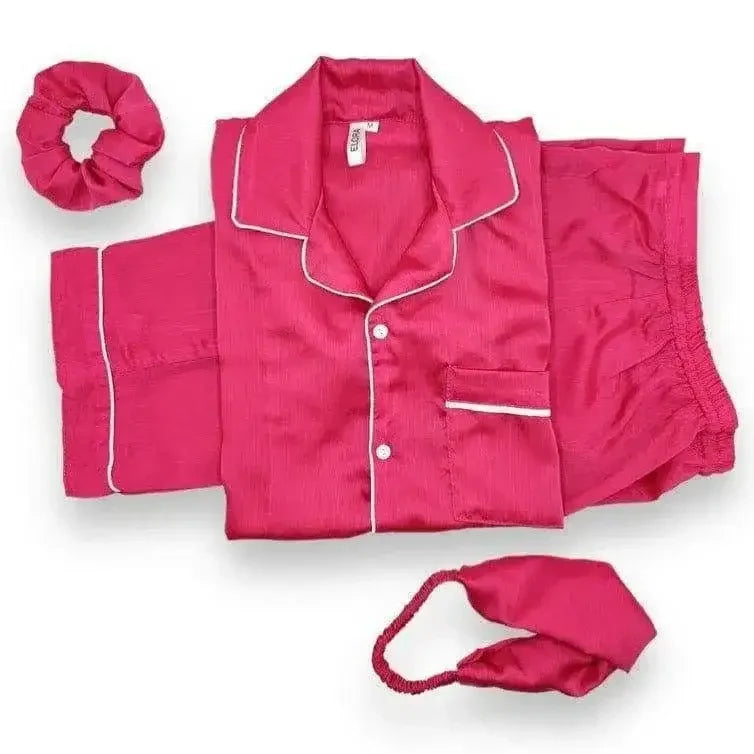 Plain fuschia pink silk pajama set with white piping, including top, shorts, scrunchie, and eye mask
