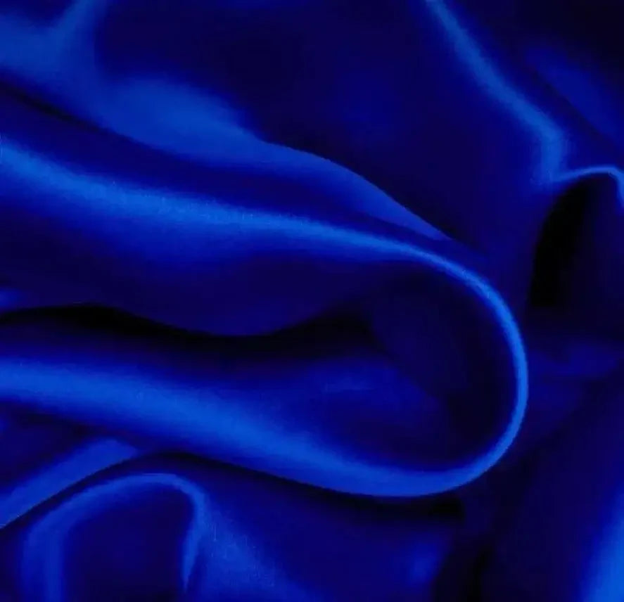 Close-up of royal blue plain silk fabric with smooth, glossy texture and gentle folds