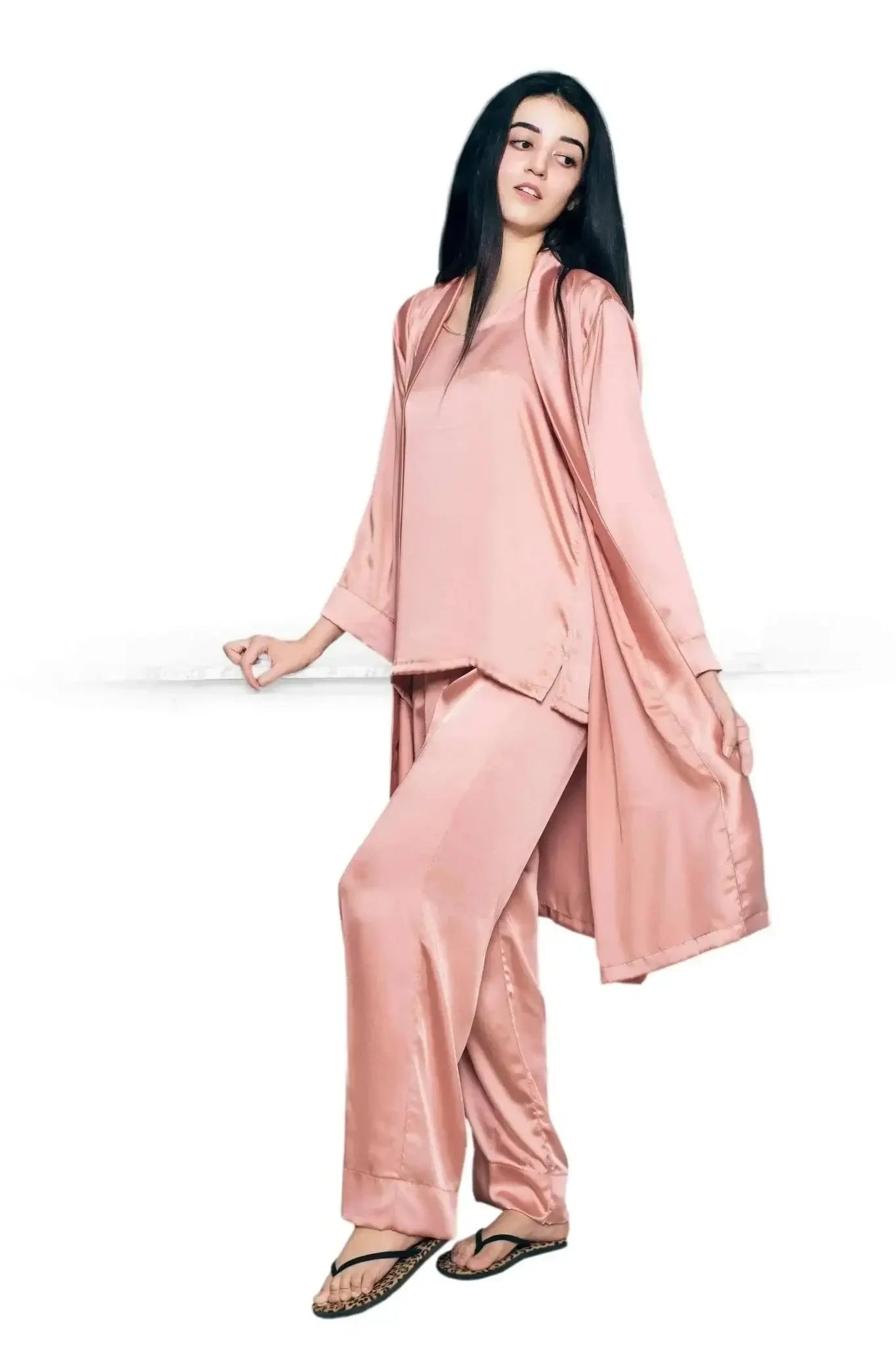 Woman wearing a blush pink satin three-piece robe set with loose pants and a long robe